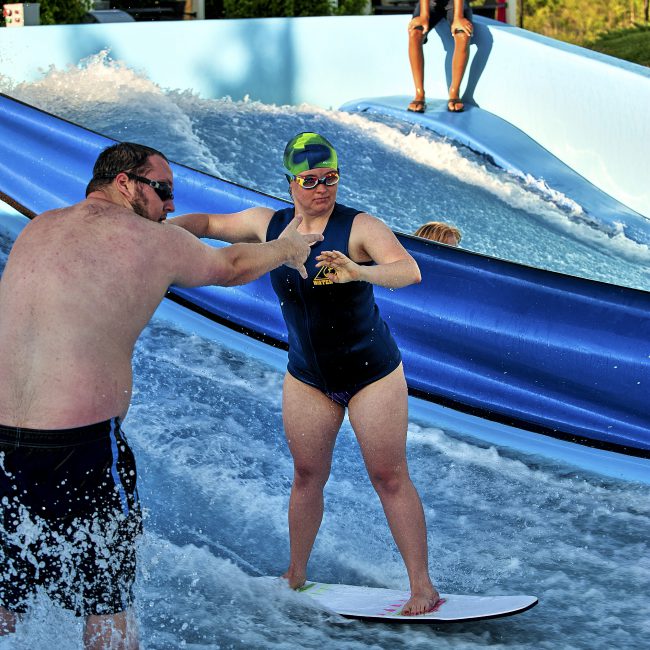 Woman on FlowRider in an adaptive lesson