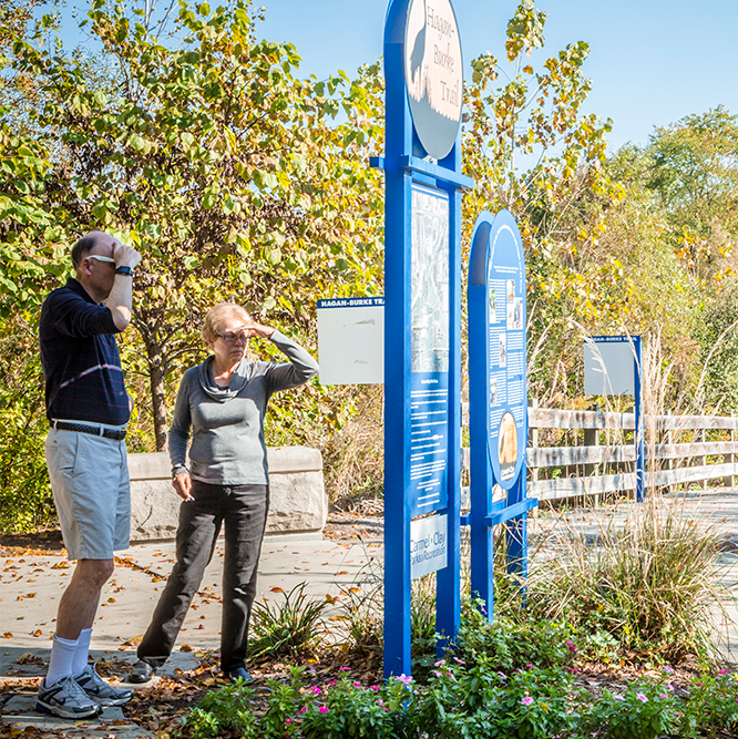 people reading a sign at Hagan Burke Trail