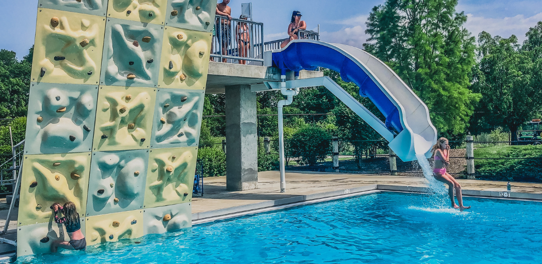 child races down the plunge slide next to the Wall in the dive well at The Waterpark