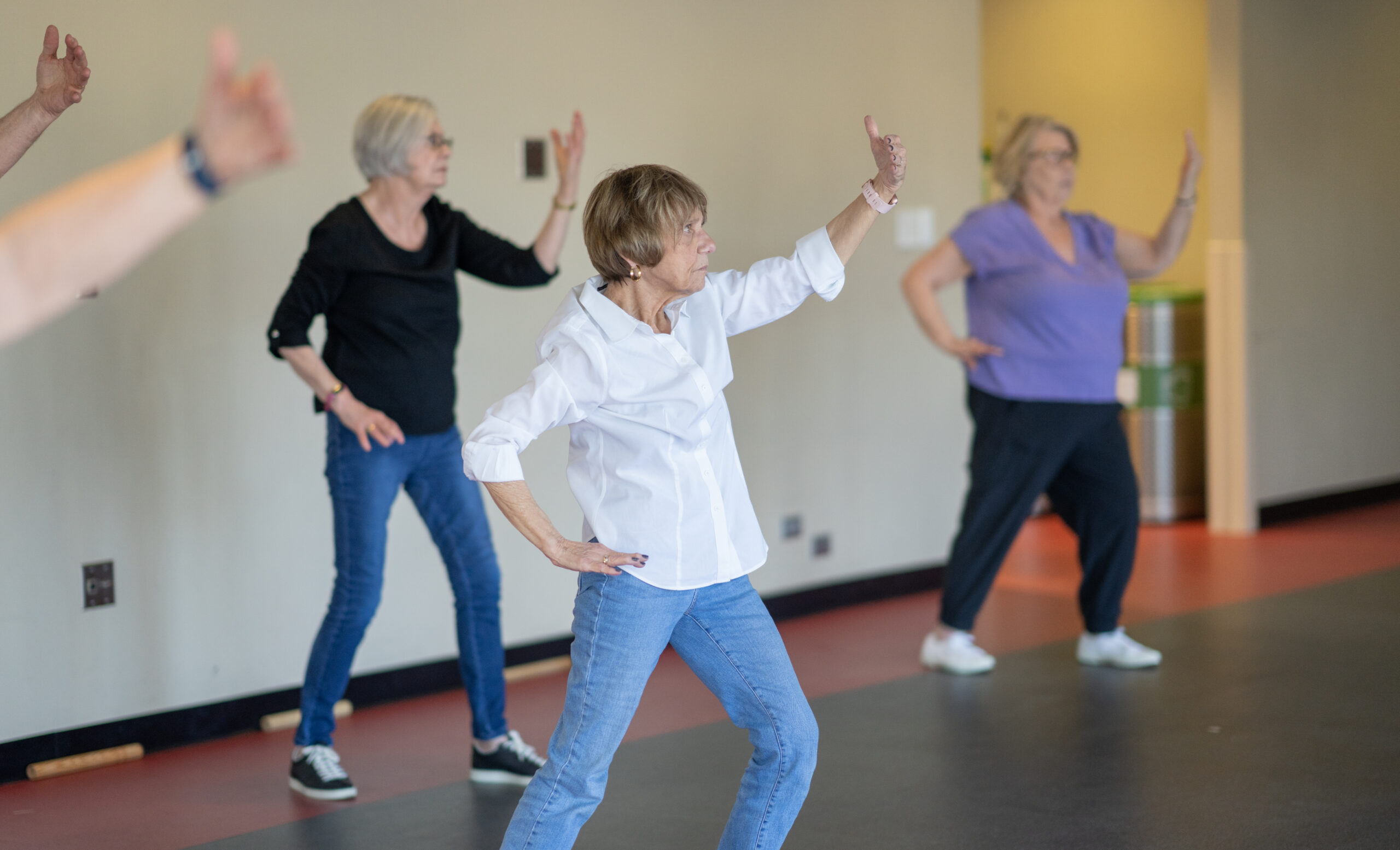 Participants move steadily through arm motions during a tai chi class at the MCC.