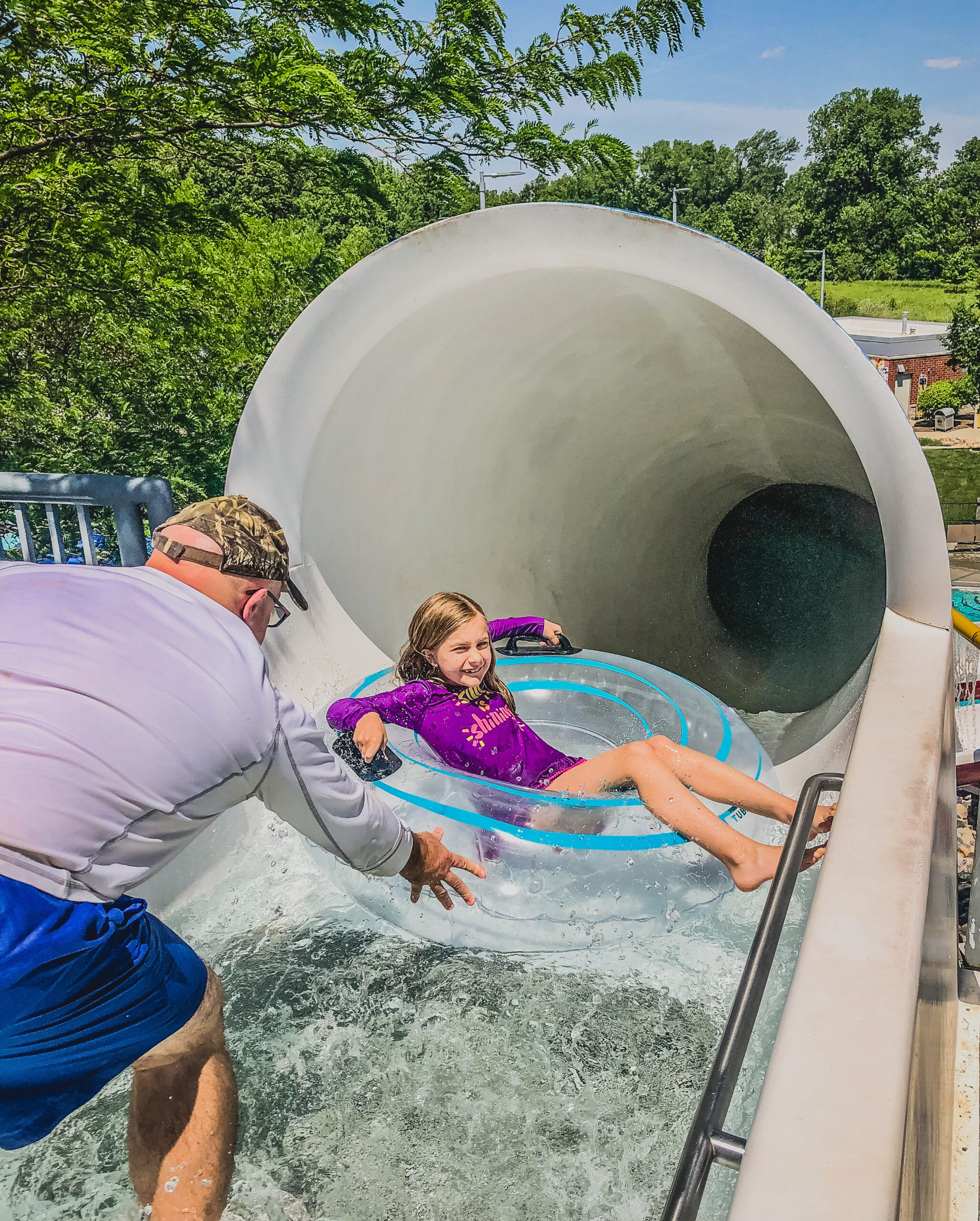 girls gets some help pushing her innertube down the blue adventure slide-view from the top