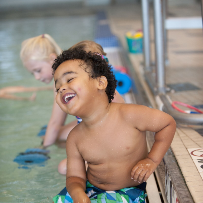 Kid smiling at swim lessons at the indoor pool in the Monon Community Center