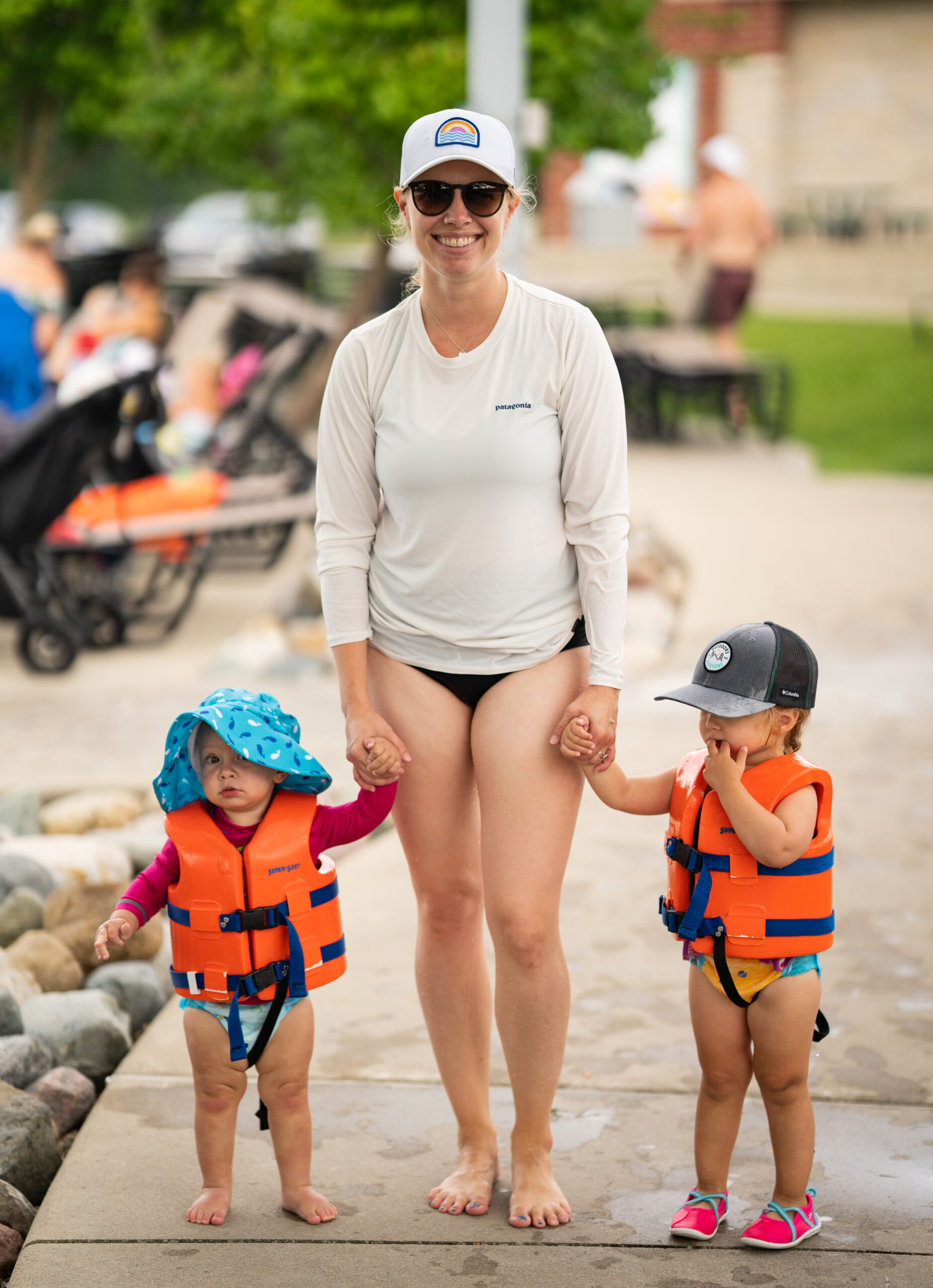Mom and her two kiddos in life vests make their way to the Kiddie Pool at The Waterpark.