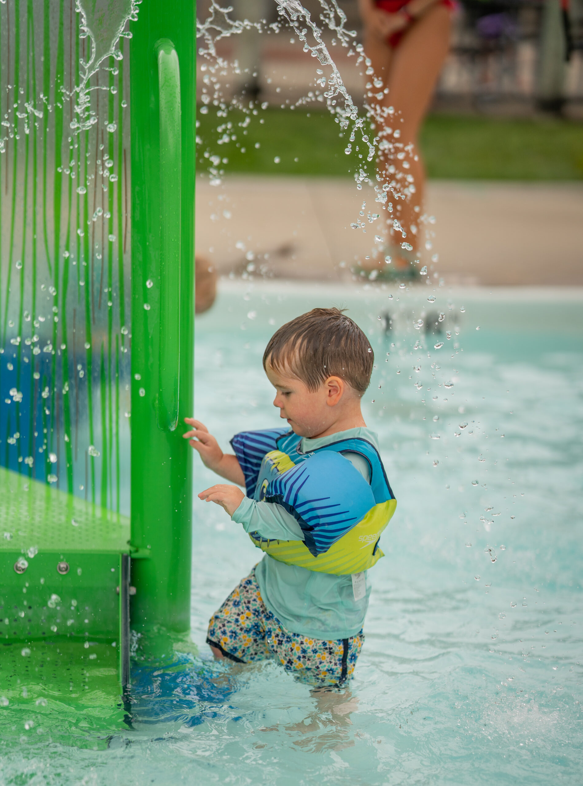 Kiddo plays with the splashing water features at the Kiddie Pool at The Waterpark.