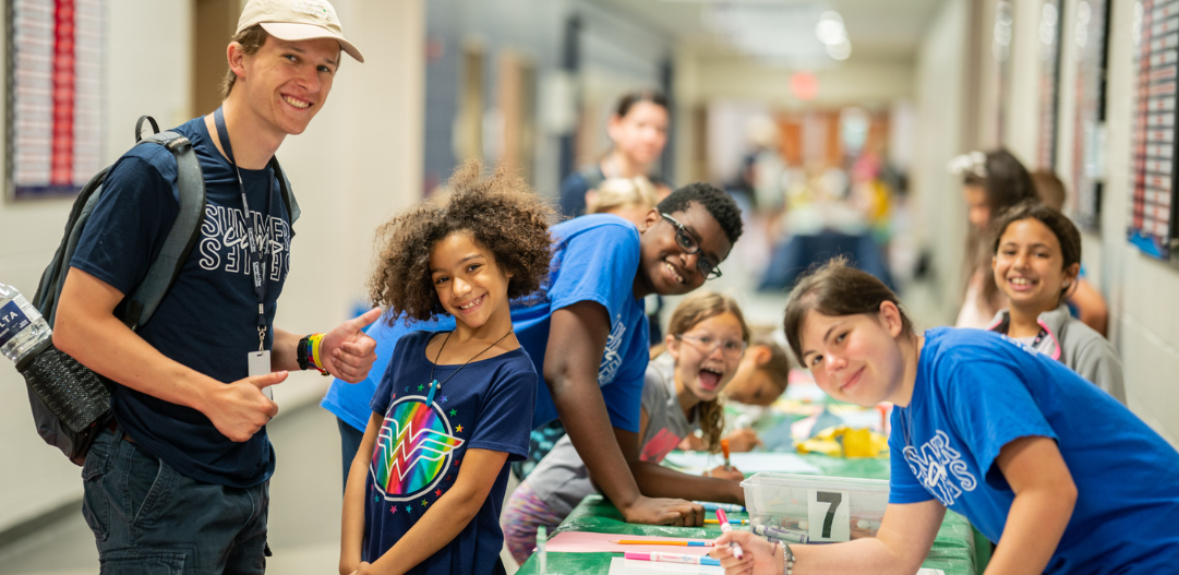 Camp counselor and kiddos enjoy a craft during Camp Summer Experience