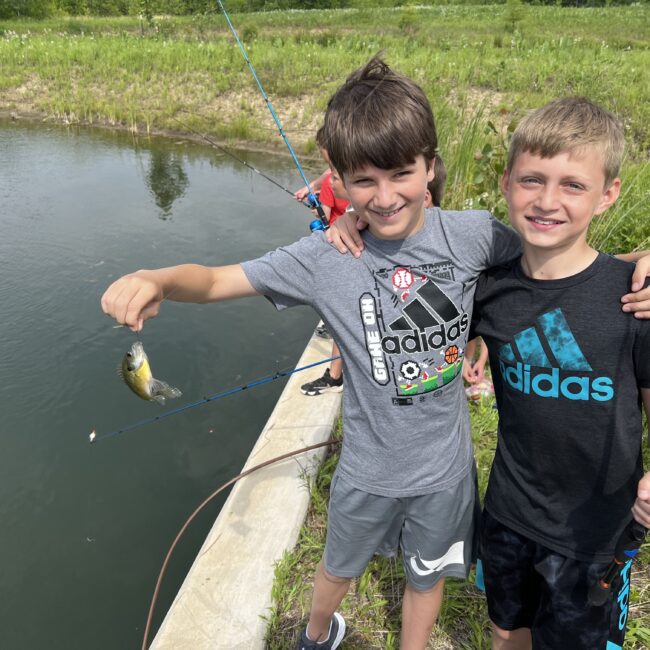 Participants hold up fish they caught in the lagoon.