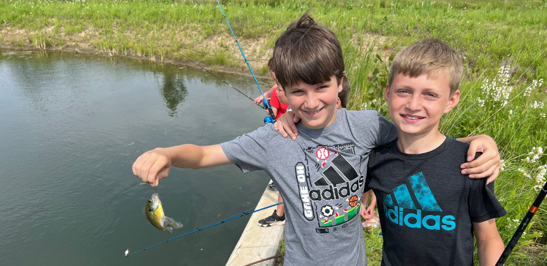Two campers smile while fishing