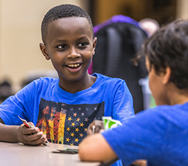 Boy playing a card game in Extended School Enrichment (ESE)