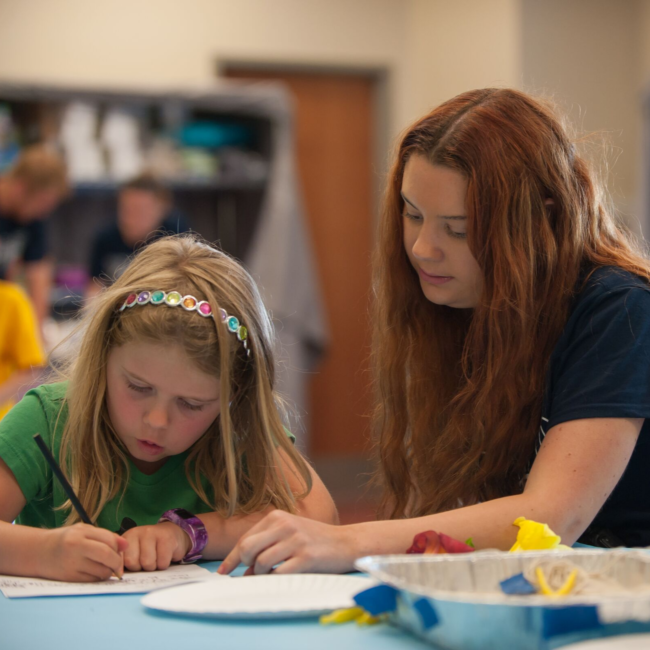 Camp counselor teaching kids science at a science of summer camp