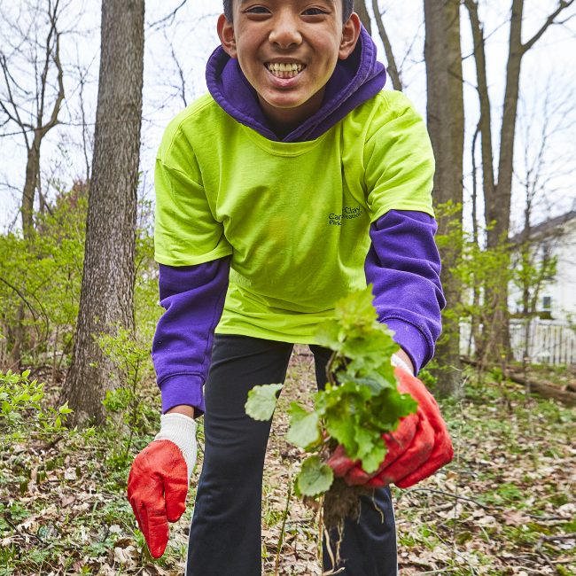 Boy smiling while cleaning up a park