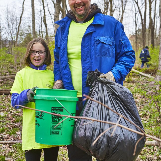 Smiling family volunteering in our park clean up project