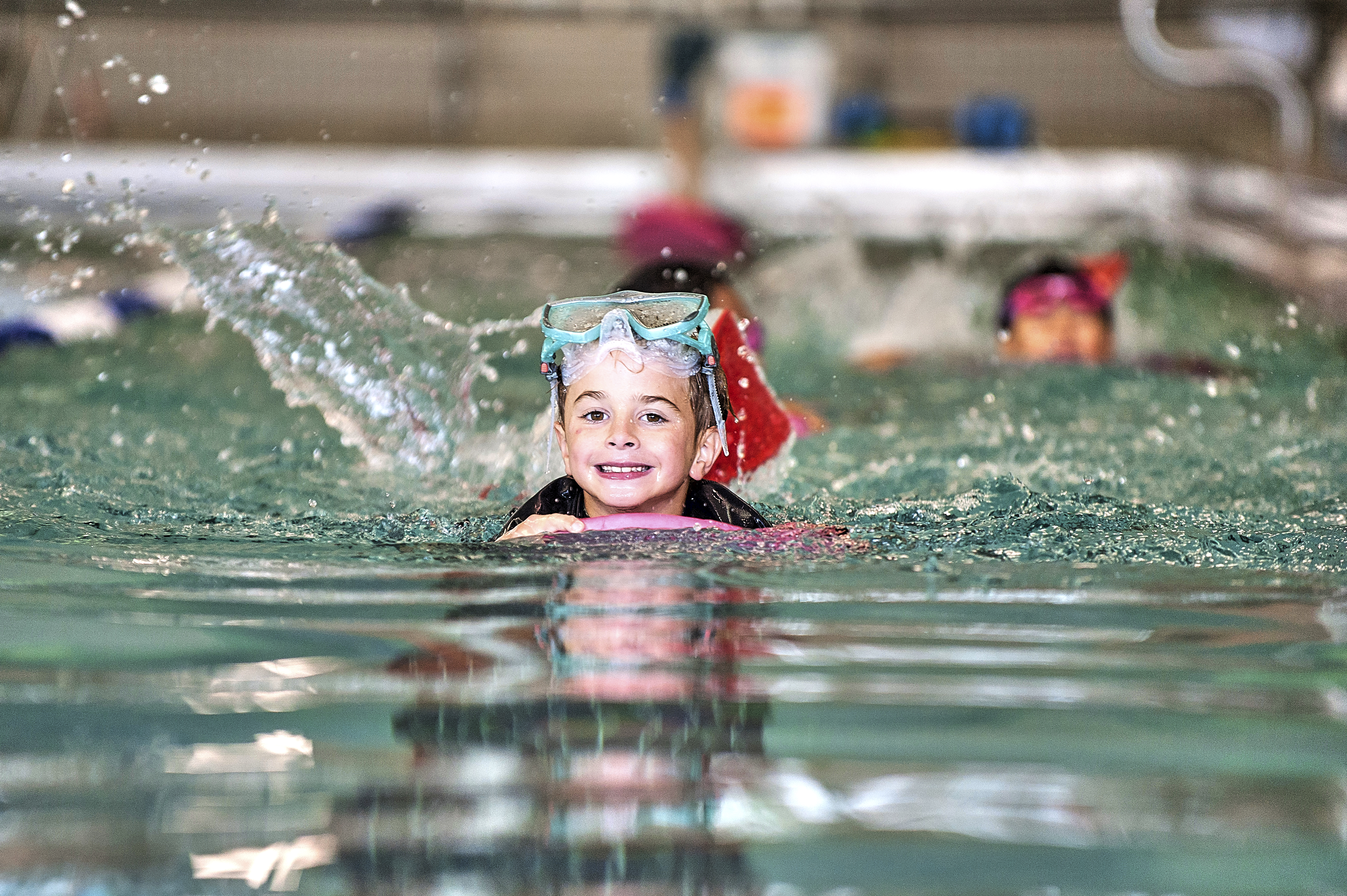 Kids swimming and smiling in the pool