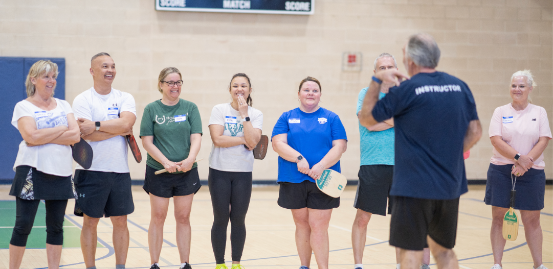 Beginner Pickleball Class laughs and has fun together in the gym at the MCC.