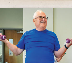 Hank Levandowski lifting weights during SilverSneakers group fitness class at the MCC