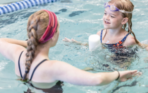 Swim instructor working with participant in the pool