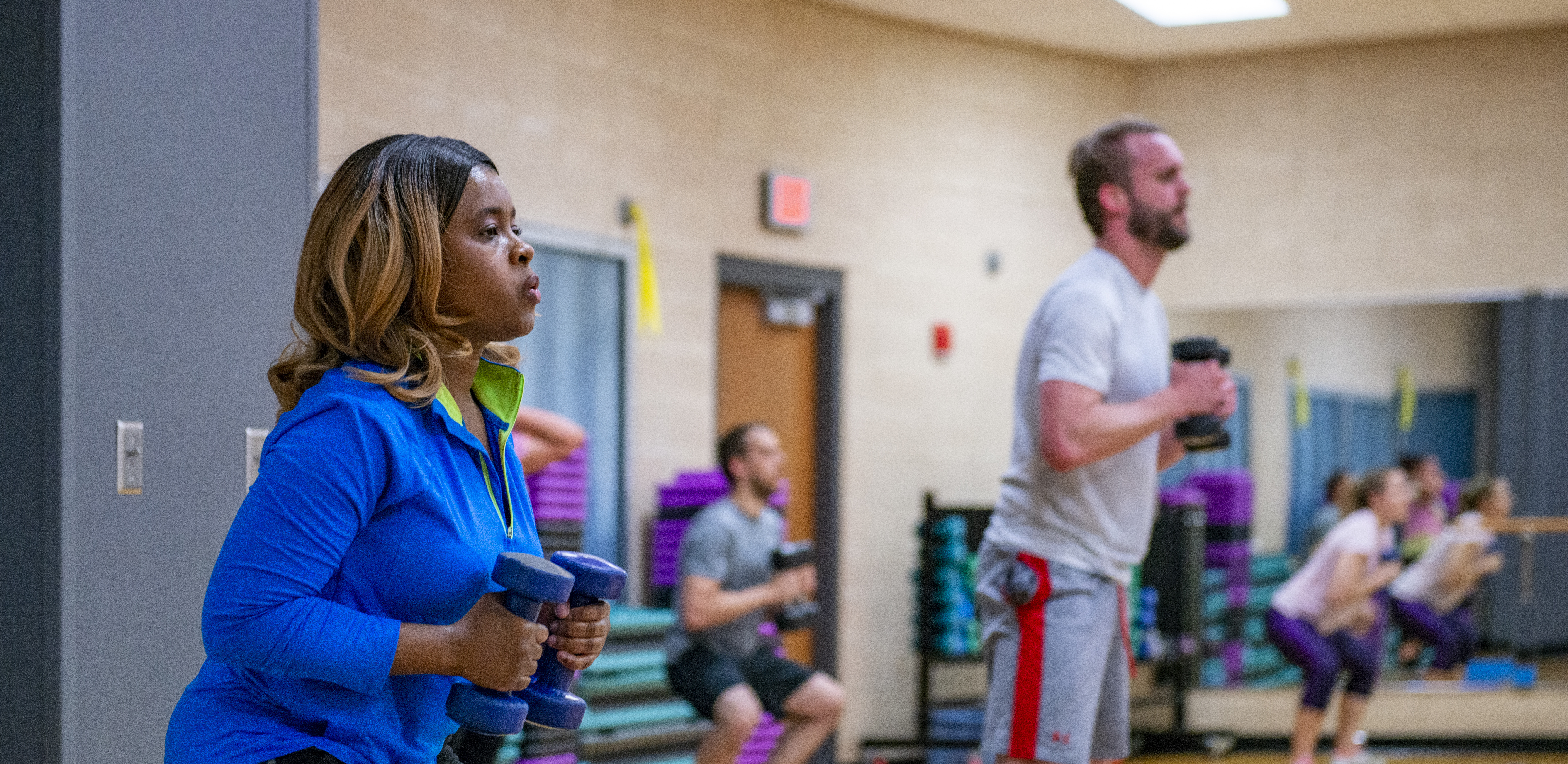 Woman lifting weights in a group fitness class