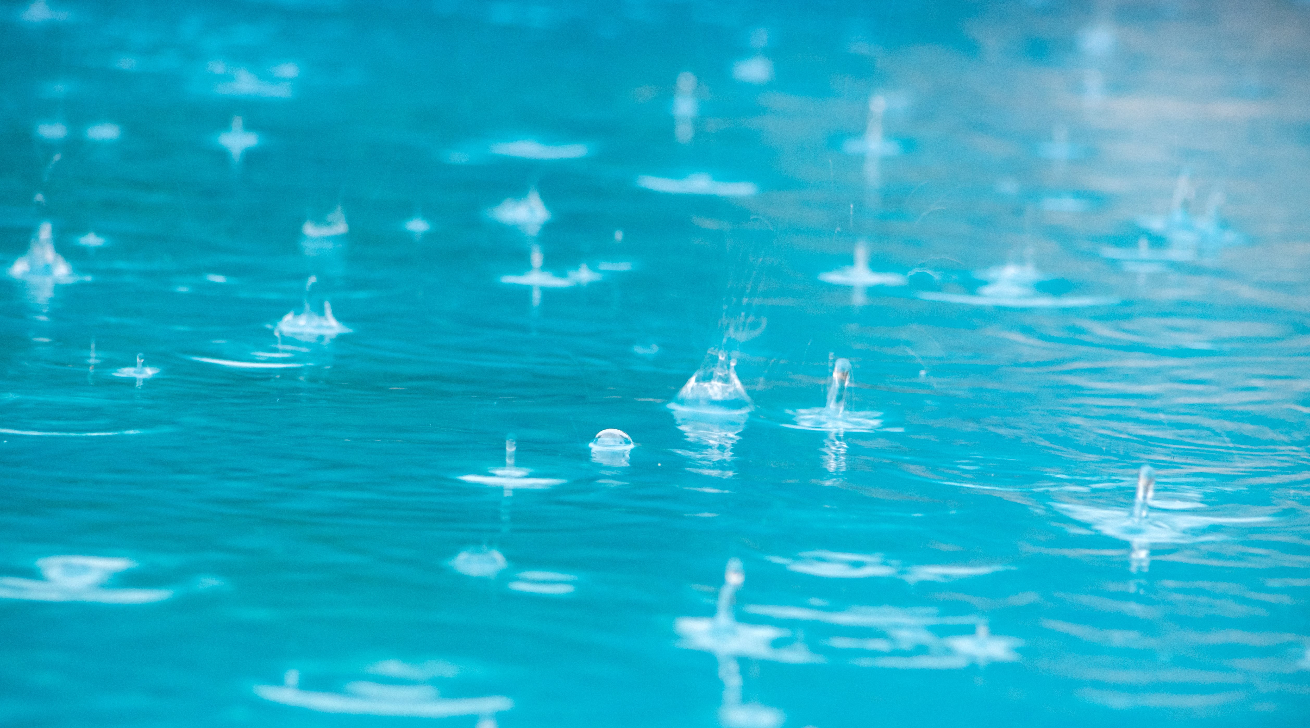 Close up of rain drops falling on a swimming pool