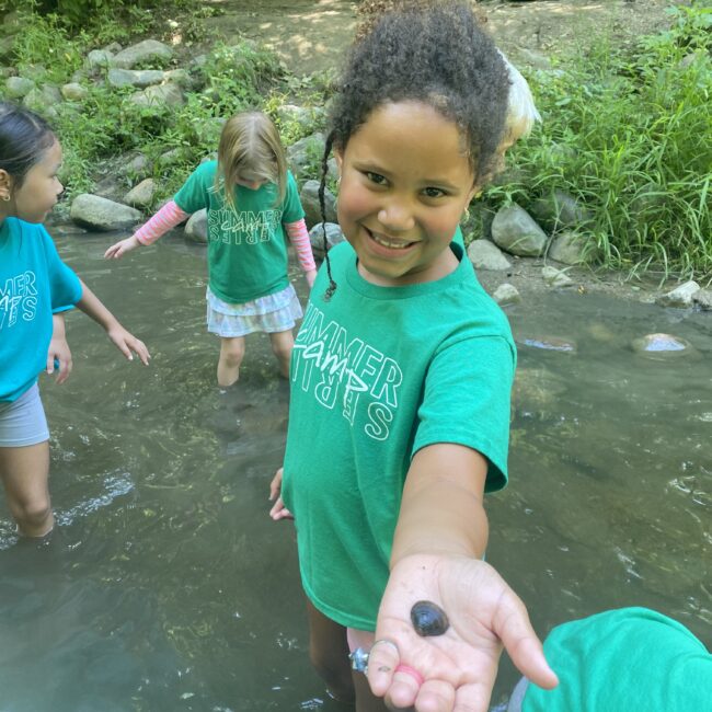 student shows off river find at Camp Wayback.