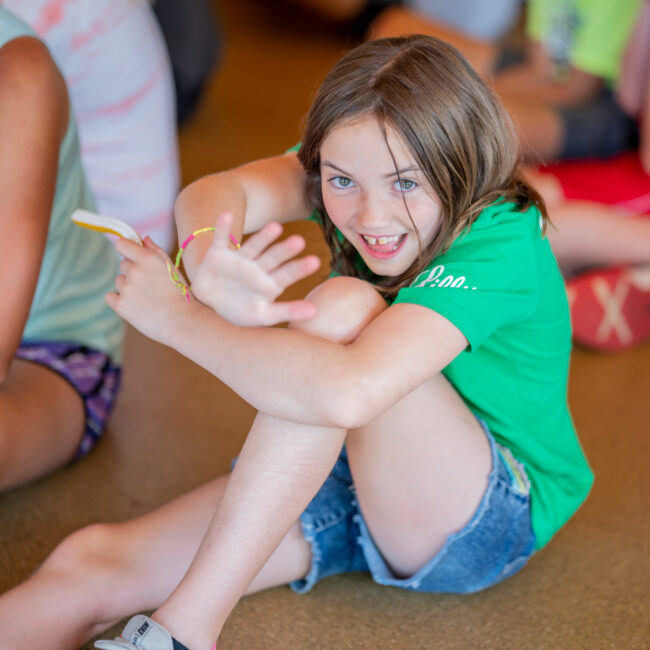 Student smiling during presentation about farm to table at STEAM camp.