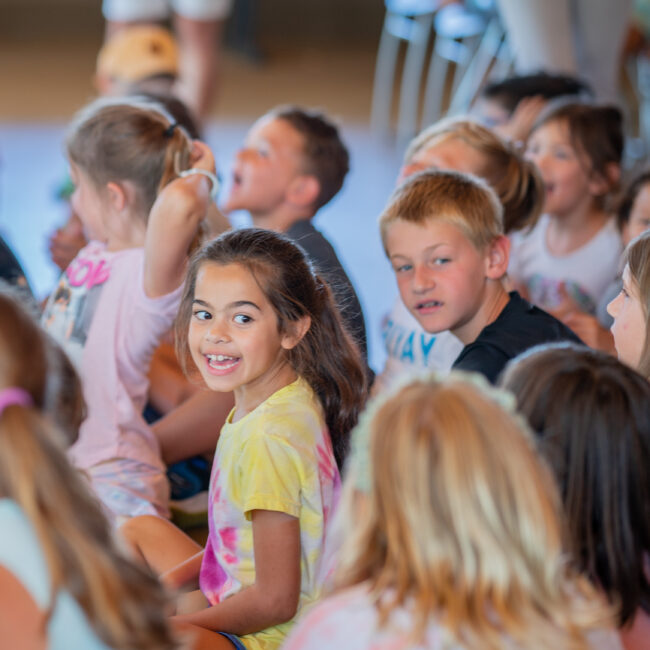 Student smiling during presentation about farm to table at STEAM camp.