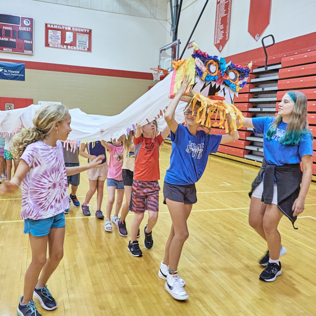 Participants, lead by a student IMPACT leader, parade a full size Chinese dragon through the gym.