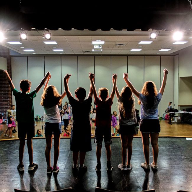 Kids in a play take a bow during dress rehearsal at the success on stage camp.