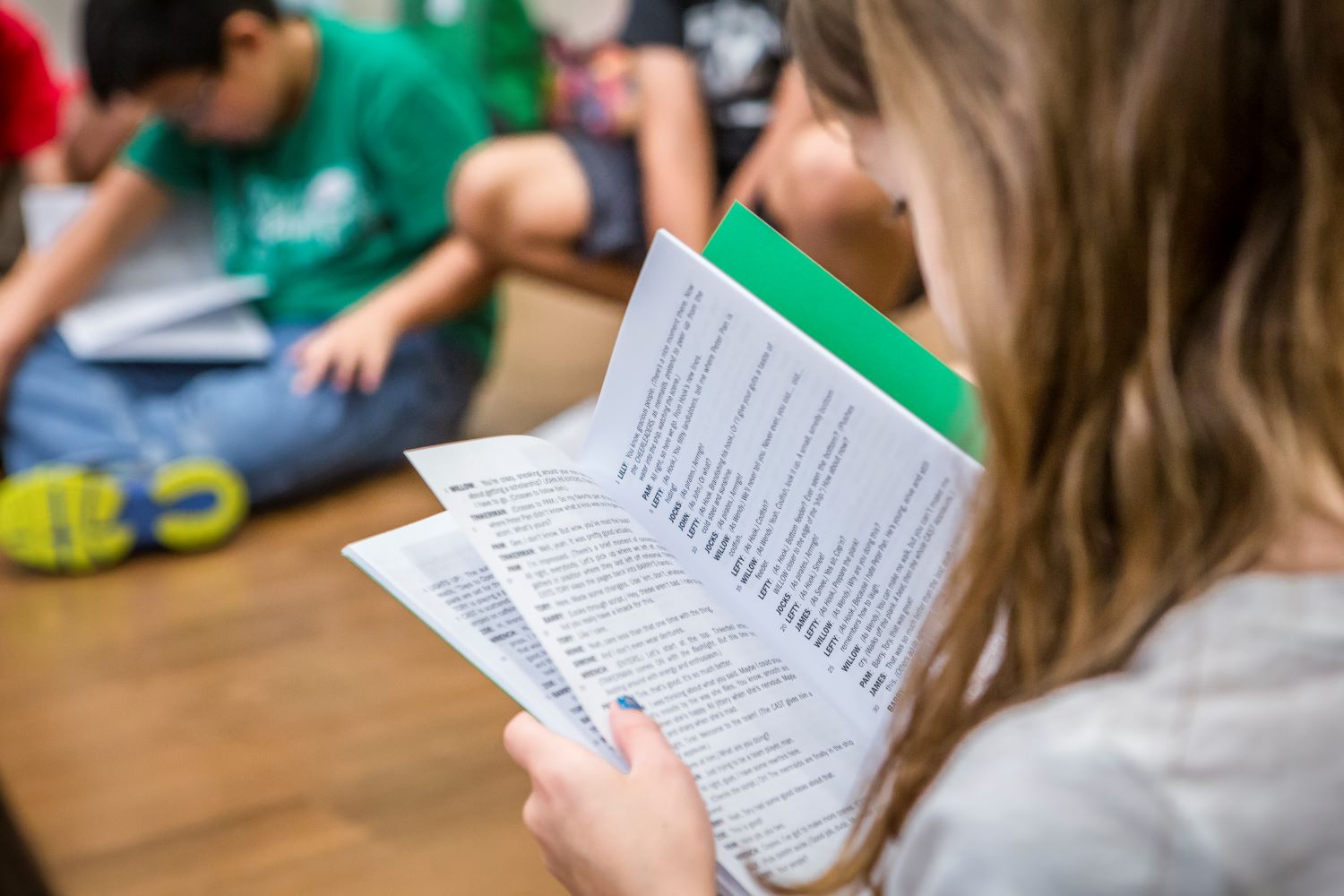 Girl reading over a script during success on stage camp