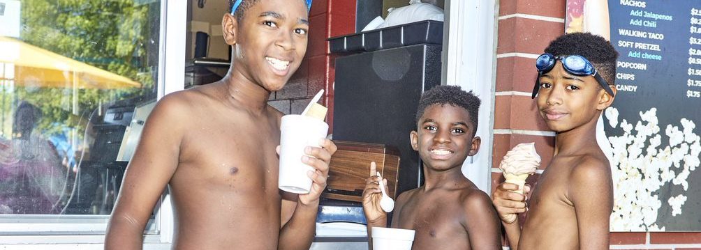 Children holding ice cream cones at the concession stand at the waterpark.