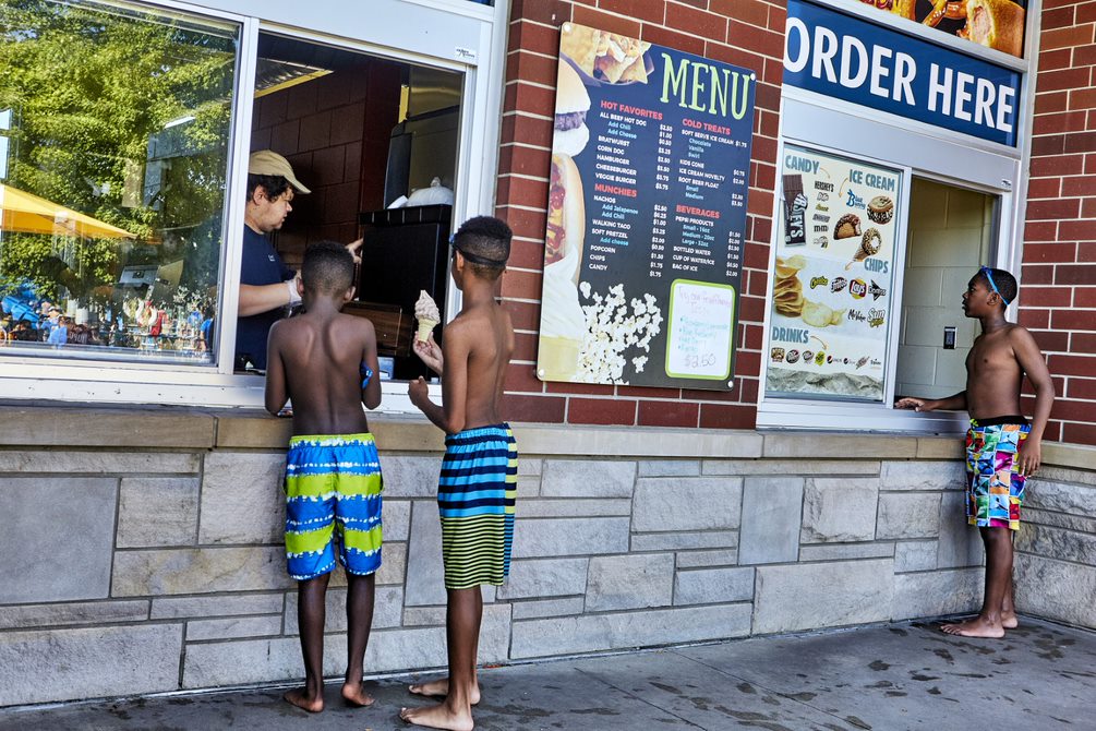 Children receive ice cream cone at concession stand at the waterpark.