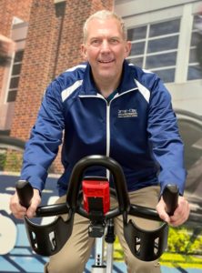 Cycling instructor Brian Krull sits on the leader bike in the cycling studio in the MCC.