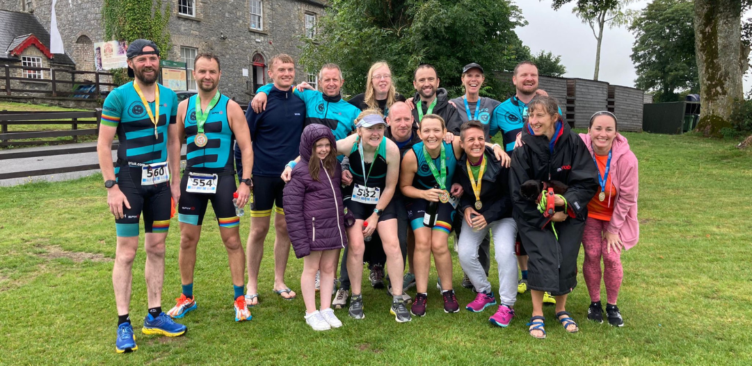 Janine Beazley at the end of her iron man race in Dublin, Ireland posing for a photo with family and friends that supported her during the race.
