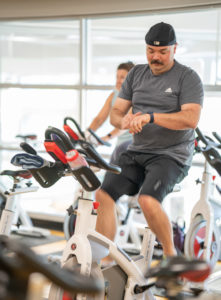 Matt P. checks his watch settings as he prepares for cycle class to begin.