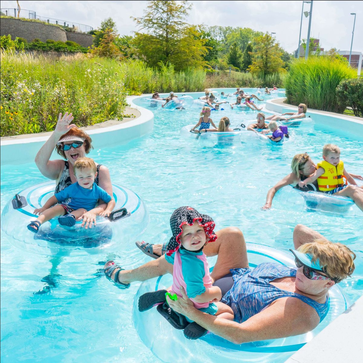 Visitors wave at the camera in the lazy river at The Waterpark.