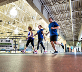 3 guests run and walk on the indoor track at the MCC.