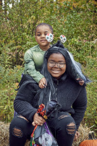 Sensory friendly trick or treat participants stop and smile for a photo.