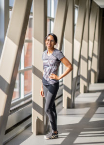 Monon Community Center member Nicole S. posing by the bright window light of the Oasis in the MCC.