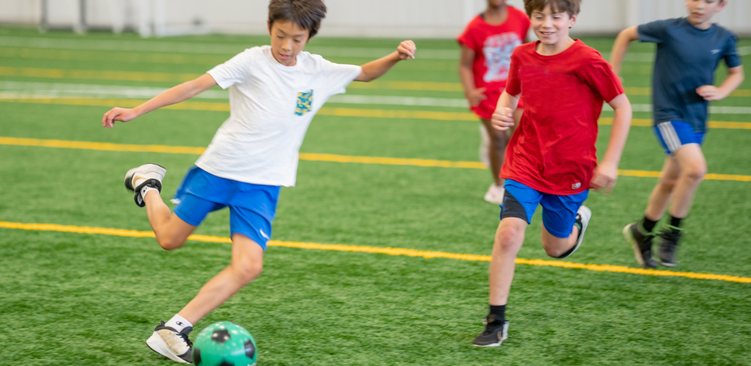 In the Zone camp participant goes for the gold during a soccer game winning shot.