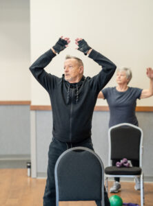 MCC Member Gary does jumping jacks during a group fitness class.