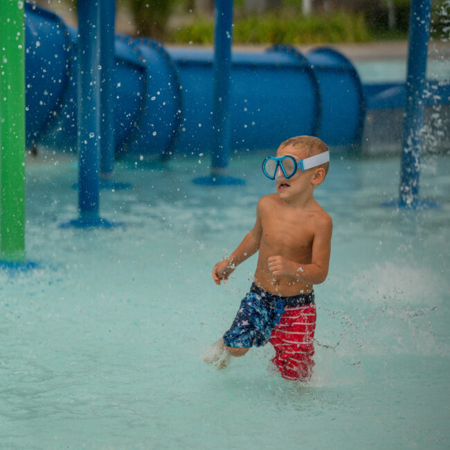 Child races across the water in the activity pool at The Waterpark.