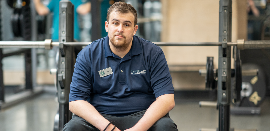 MCC Member Services Supervisor Ryan G. sits at the weight lifting bench in the fitness center.