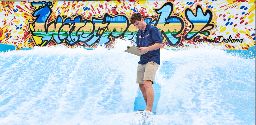 Sean R. checking his Waterpark to-do list on his clipboard while riding the FlowRider.
