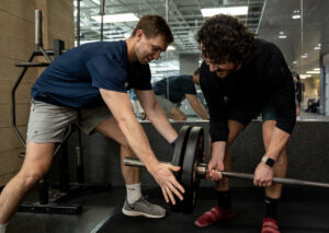 MCC members Matt & Sam help each other get the weight discs on the bar at the dead lift platform.