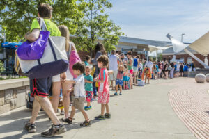 Visitors wait in line in front of The Waterpark.