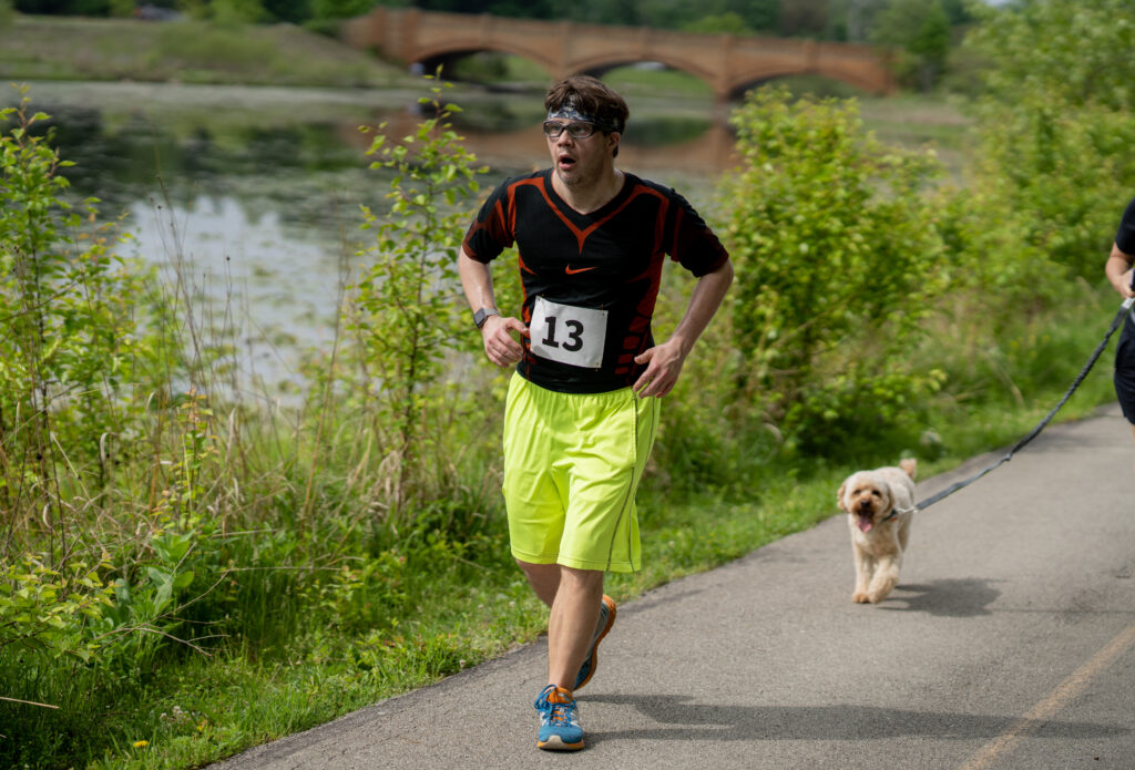 Tomas Sliva running in the Adaptive 5k in front of the Central Park bridge and lagoon.