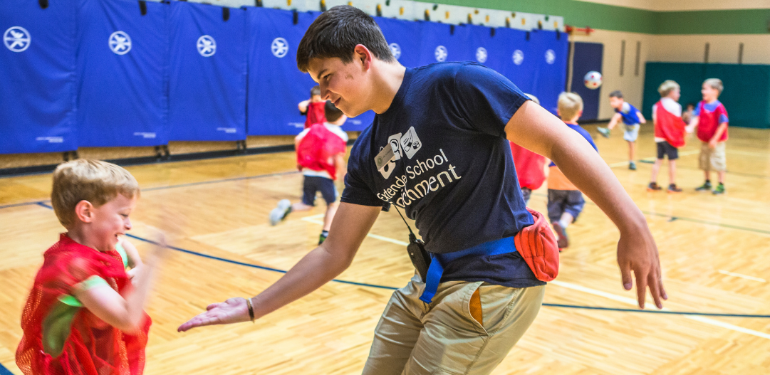 ESE counselor high fives a student in the gymnasium.