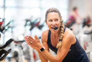 Expert spin group fitness instructor teaching class.