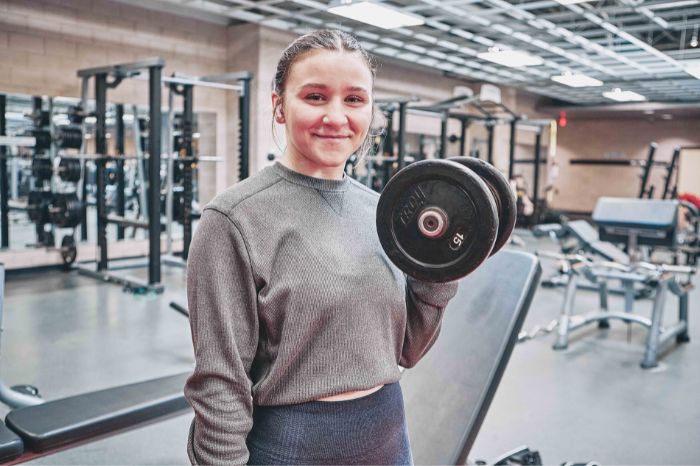 Young woman lifting weights in the Monon Community Center.